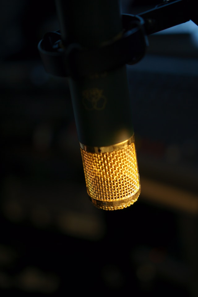 zylindrisches Mikrophon mit Goldenem Metallnetz, schwarzer Hintergrund